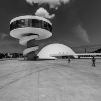 Imagen en blanco y negro del Centro Cultural Niemeyer con una nube sobre la torre mirador