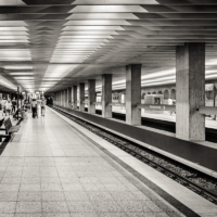 Imagen en blanco y negro del interior de la estaci&oacute;n con algunas personas en los andenes.