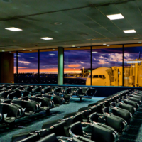 Imagen de la zona de espera del la terminal, con el morro de un avi&oacute;n asomando por las cristaleras.