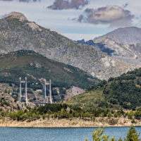 Imagen lejana del puente, asomando a lo lejos tras una de las islas del embalse.